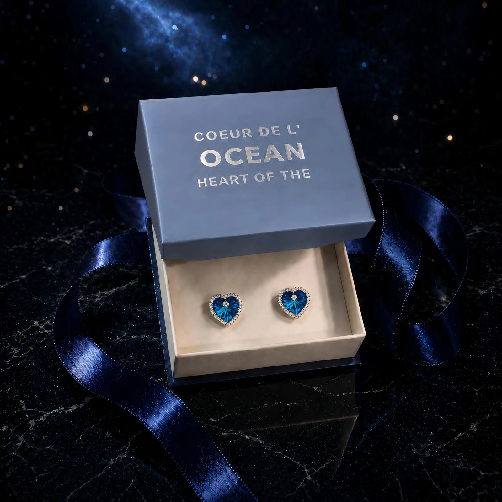 Boucles d'oreilles Coeur de l'Ocean présentées dans leur écrin bleu avec boîte cadeau élégante