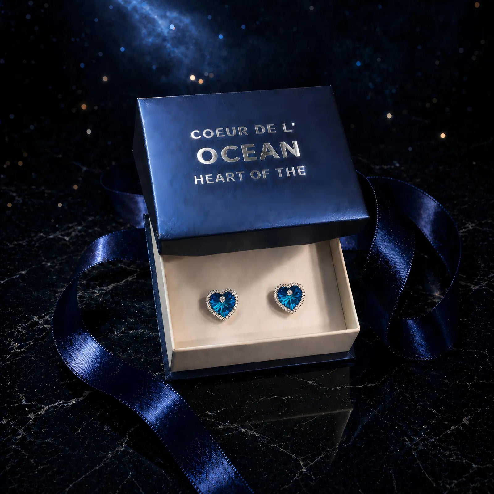 Boucles d'oreilles Coeur de l'Ocean présentées dans leur écrin bleu avec boîte cadeau élégante