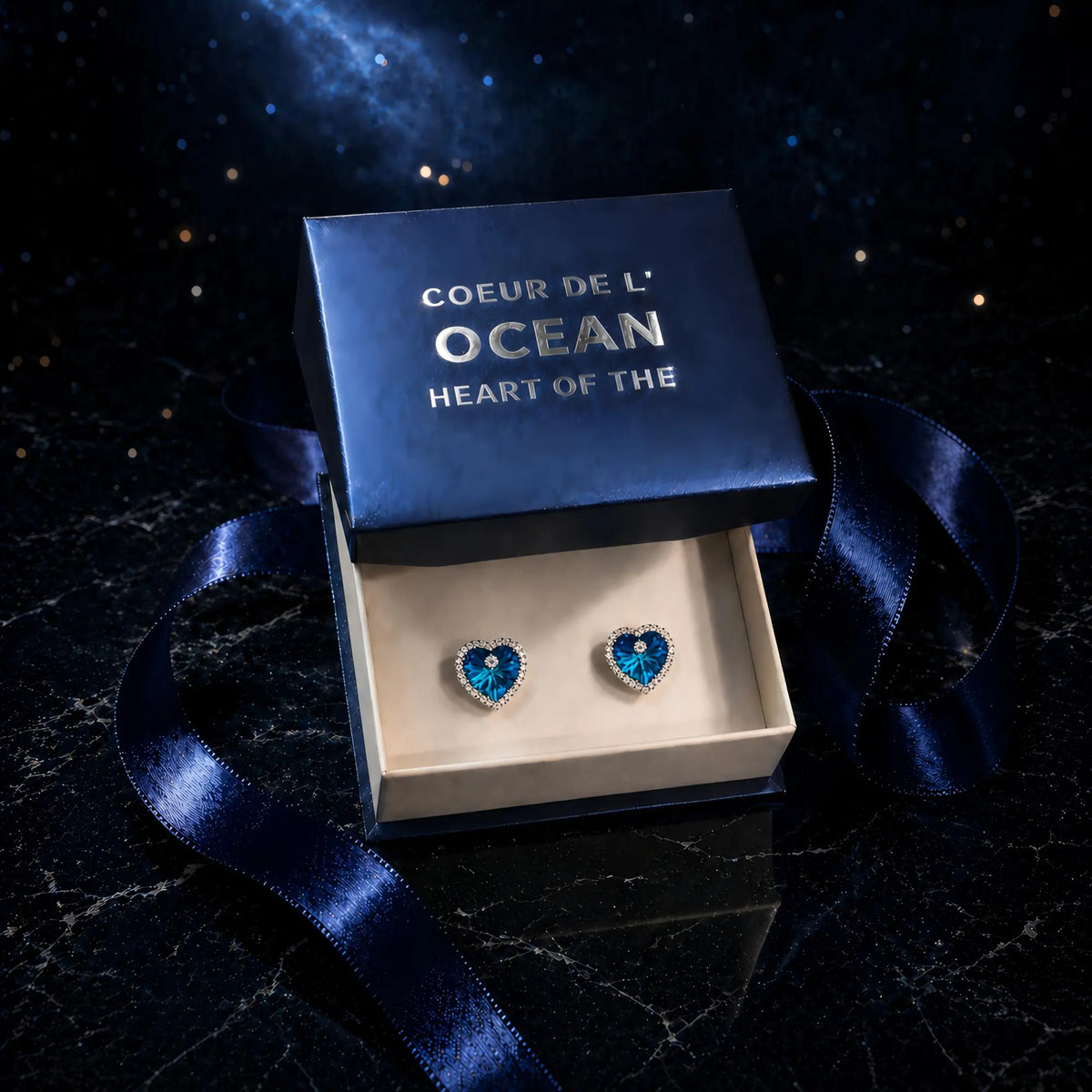 Boucles d'oreilles Coeur de l'Ocean présentées dans leur écrin bleu avec boîte cadeau élégante